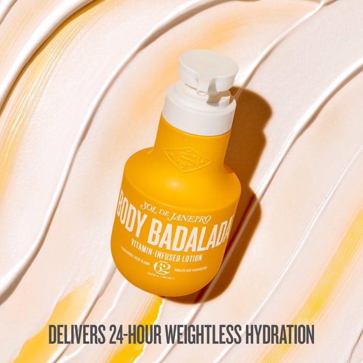 Sol de Janeiro Body Badalada 400 ml vitaminberiget bodylotion i gul pumpeflaske over cremet hvid tekstur