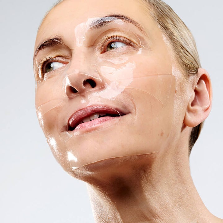 Currentbody Skin Hydrogel Face mask 26 g fugtgivende sheet mask påført en kvindes ansigt for glød