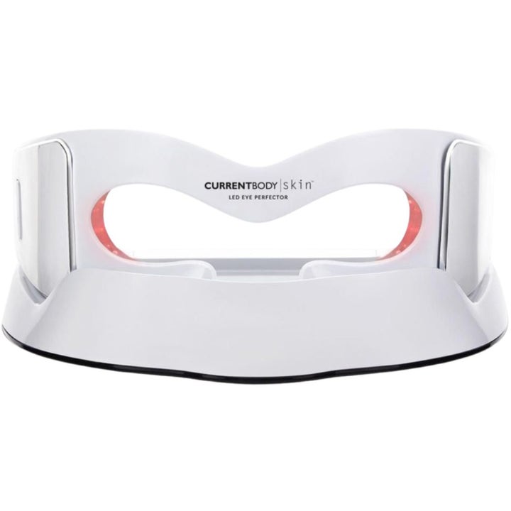 Currentbody Skin LED Eye Perfector hvid øjenmaske mod rynker placeret i en matchende ladestation