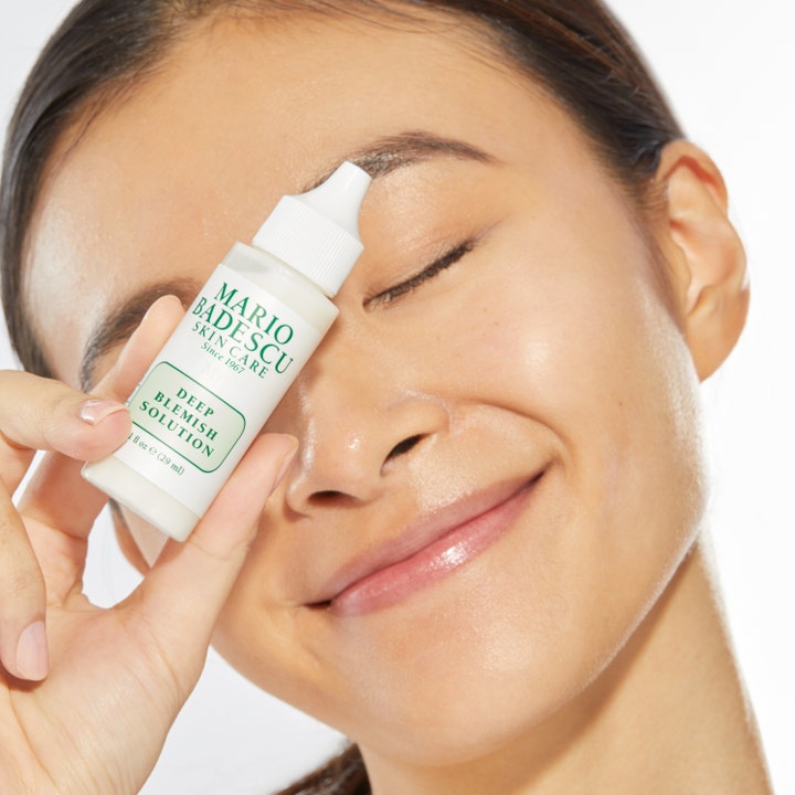 Mario Badescu Deep Blemish Solution 29 ml spot treatment i hvid plastflaske holdt af smilende kvinde