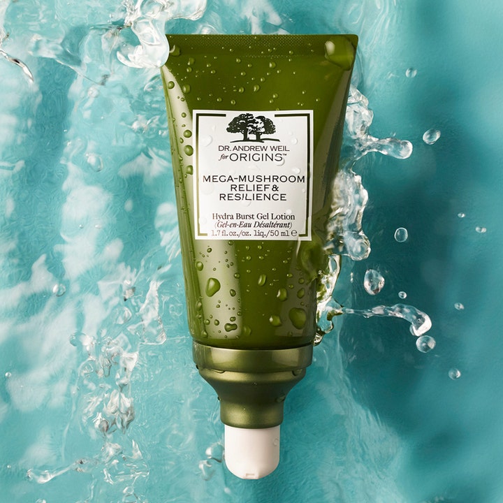 Origins Dr. Weil Mega-Mushroom Relief & Resilience 50 ml beroligende gel lotion i grøn tube omgivet af vand