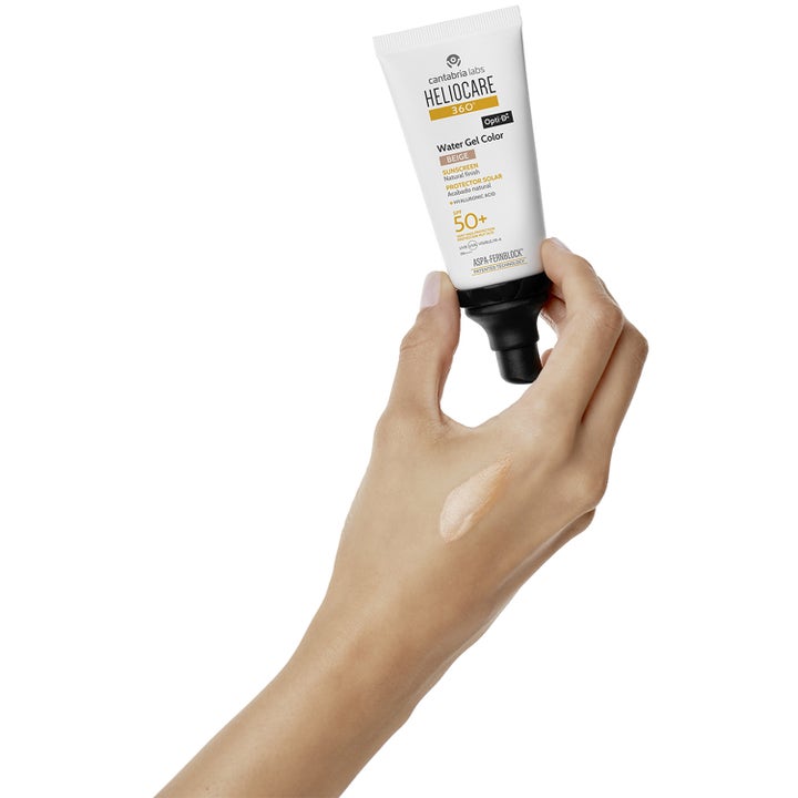 Heliocare Water Gel Color SPF 50+ Beige 50 ml solcreme til ansigtet i hvid tube med beige teksturprøve på huden