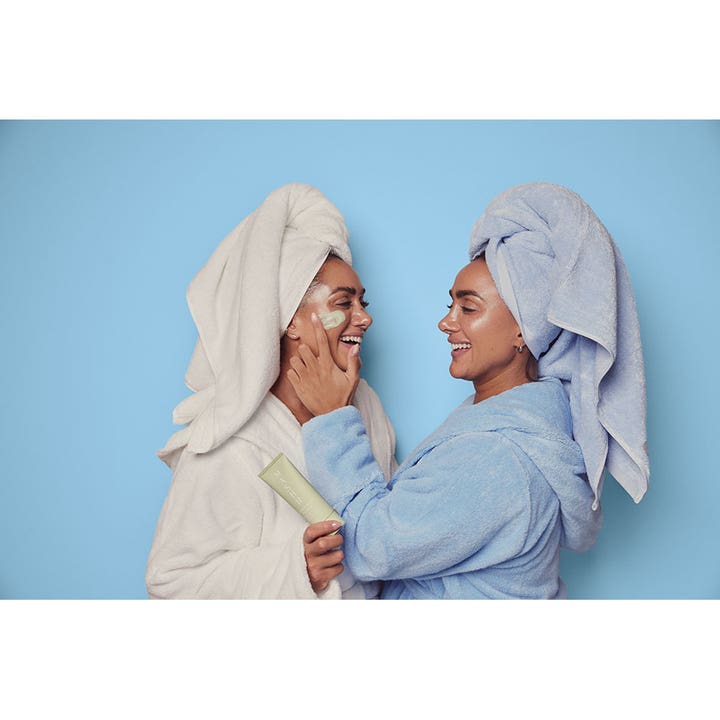 MASHH Green Refresh & Peel Mask 100 ml ansigtsmaske påføres af to kvinder i badekåber mod blå baggrund