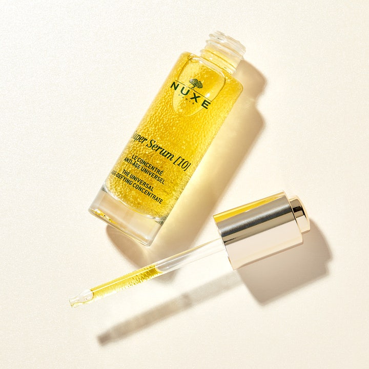 Nuxe Super Serum 30 ml anti-age serum med gyldne mikrokugler i åben glasflaske og pipette med guldhætte