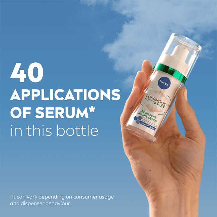 NIVEA LUMINOUS 630 Post-Acne Marks Serum 30 ml i gennemsigtig pumpeflaske holdt mod blå himmel