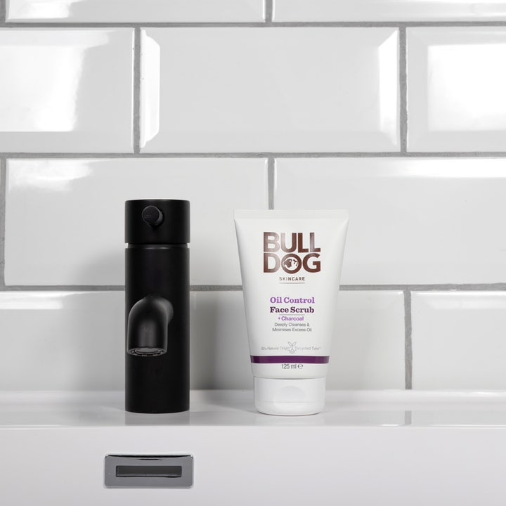 Bulldog Oil Control Face Scrub 125 ml dybderensende ansigtsskrub i hvid tube ved siden af sort vandhane