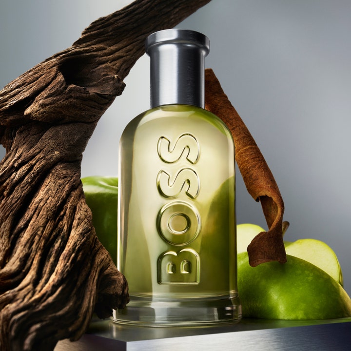 Hugo Boss Boss Bottled 75 ml herreduft omgivet af rustikt træ, kanelstang og friske grønne æbler