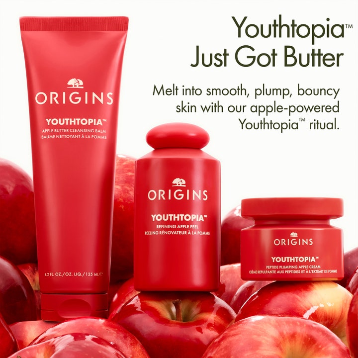 Origins Youthtopia Apple Butter Cleansing Balm 125 ml i rød tube omgivet af friske røde æbler