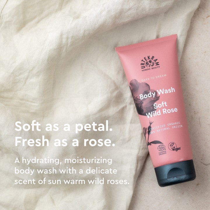 Urtekram Body Wash Soft Wild Rose 200 ml fugtgivende kropspleje i lyserød tube på lyst stof