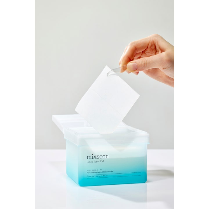 Mixsoon Bifida Toner Pad 120 stk styrkende ansigtspleje i blå boks hvor en hvid pad tages op med pincet.