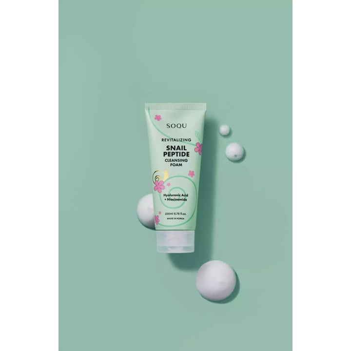 SOQU Snail Peptide Cleansing Foam 200 ml revitaliserende ansigtsrens i mintgrøn tube omgivet af hvide skumbobler.