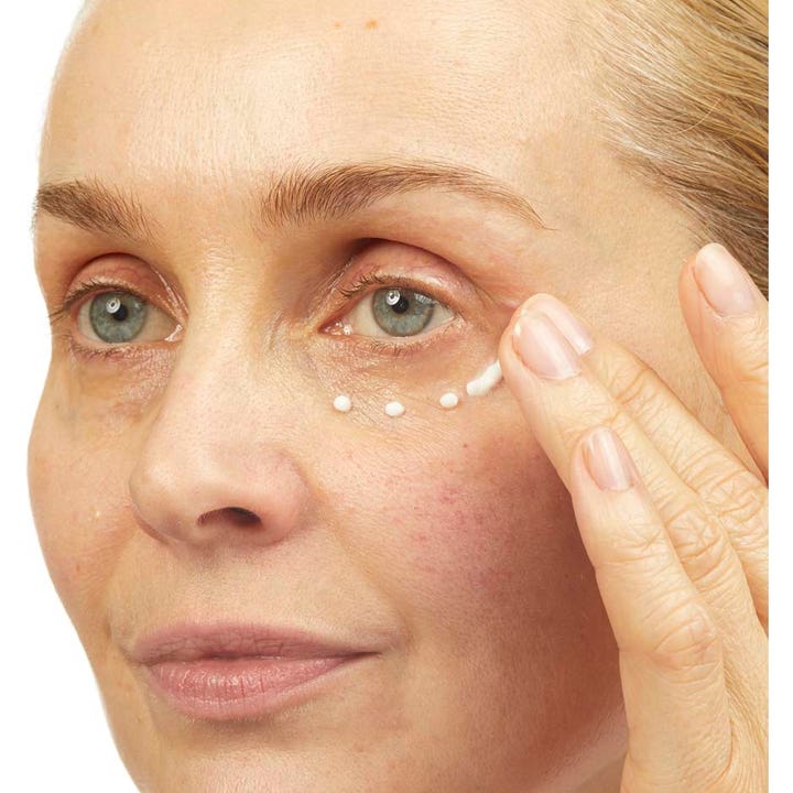 No7 Lift & Luminate Triple Action Eye Cream 15 ml øjencreme mod rynker påføres som små hvide prikker under øjet.