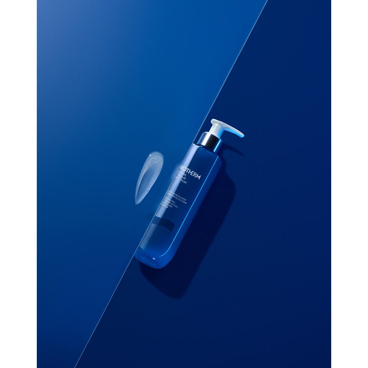 Biotherm Biocorps Body Serum 200 ml fugtgivende kropsserum i blå pumpeflaske med en klar serumdråbe ved siden af.