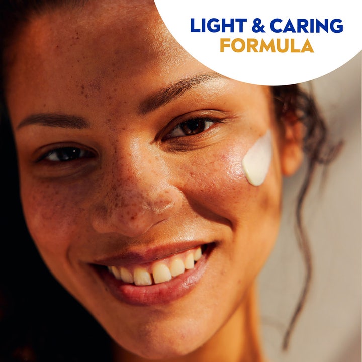 NIVEA UV Face Sensitive SPF50 50 ml solcreme med let formel på kinden af en smilende kvinde