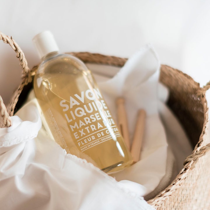 Compagnie de Provence Liquid Marseille Soap Refill 1000 ml flydende håndsæbe i klar flaske i en flettet kurv.