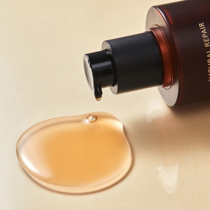 Hyggee Natural Repair Serum 120 ml reparerende ansigtspleje med en gylden flydende tekstur og sort pumpe.