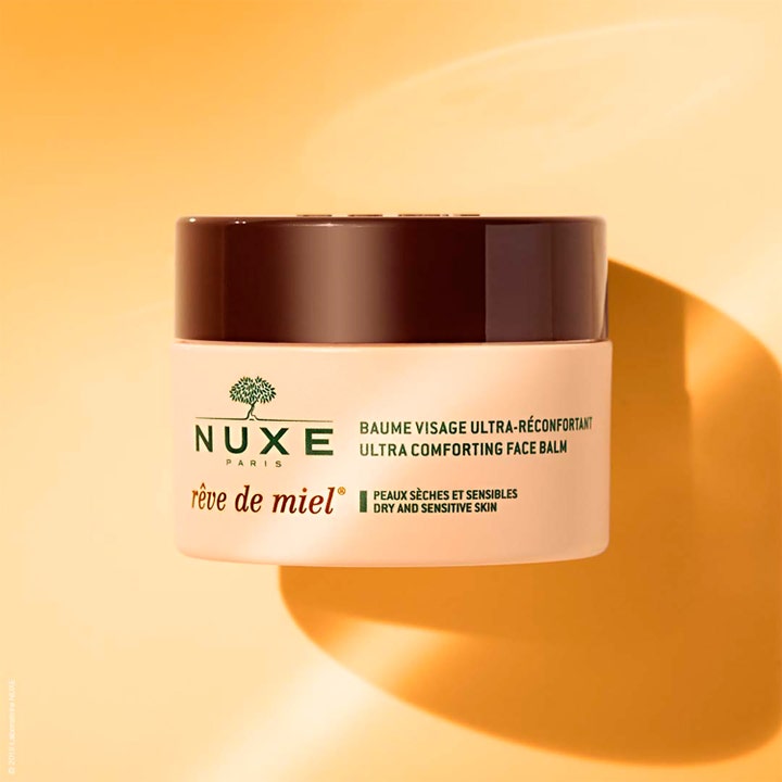 Nuxe Rêve de Miel 50 ml beroligende ansigtscreme i beige krukke med brunt låg på gul baggrund