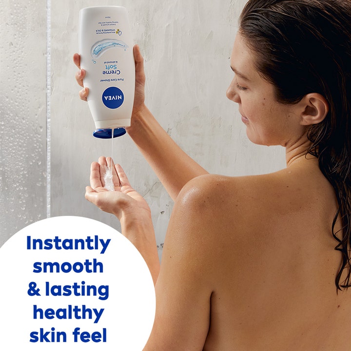 NIVEA Creme Soft Shower 250 ml plejende bodyshampoo hældes i hånden i badet for en øjeblikkelig blød hud.