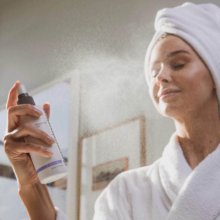 Dermalogica UltraCalming Mist 177 ml beroligende ansigtsspray sprayes direkte på huden af en kvinde i badekåbe