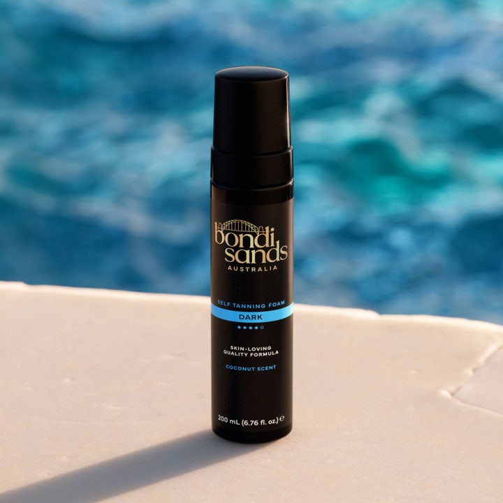 Bondi Sands Self Tanning Foam Dark 200 ml selvbruner giver dyb glød i sort flaske ved en blå pool