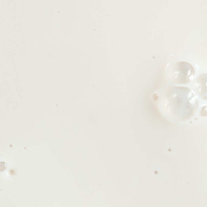 KORA Organics Silky Sun Drops 30 ml mineral sunscreen serum viser en let og cremet hvid tekstur med bobler.