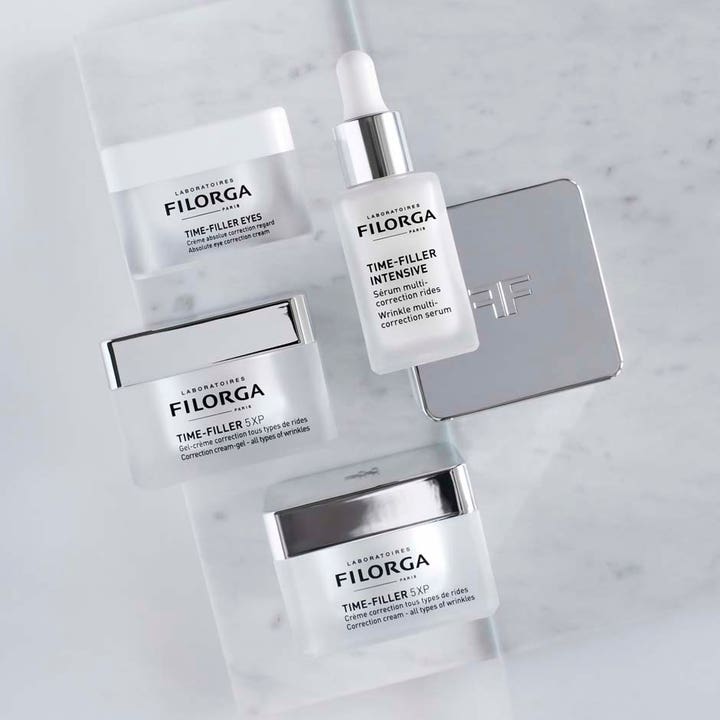 Filorga Time-Filler 5XP Cream 50 ml anti-rynke dagcreme vist i en serie af hudpleje på en hvid marmorbund