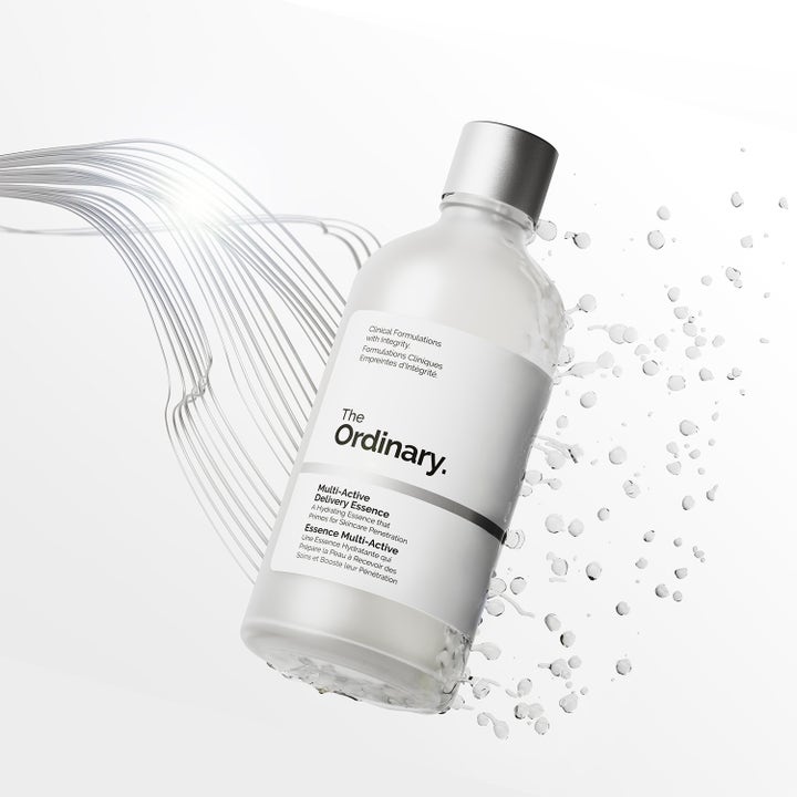 The Ordinary Multi-Active Delivery Essence 100 ml fugtgivende essence i matteret glasflaske omgivet af vanddråber