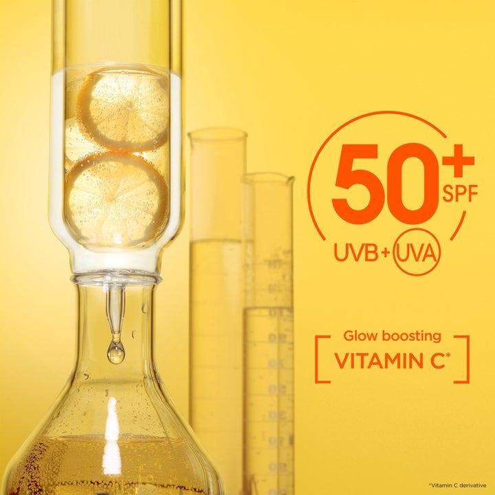 Garnier Vitamin C Serum + Daily UV glødgivende serum med SPF 50+ og citronskiver i laboratorieglas.