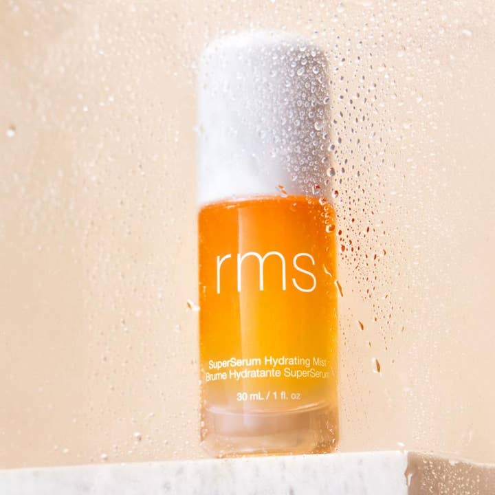 RMS Beauty SuperSerum Hydrating Mist 30 ml fugtgivende face mist i orange flaske set gennem duggede vanddråber