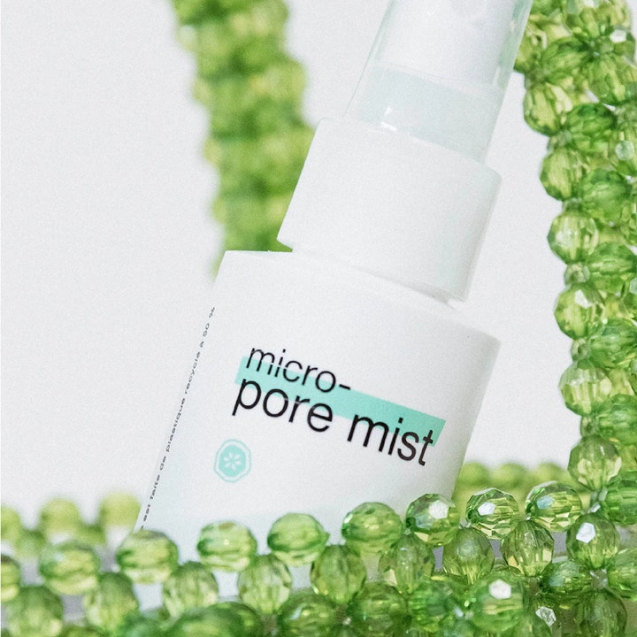 Dermalogica Clear Start Micro-Pore Mist 118 ml ansigtstoner i hvid sprayflaske omgivet af grønne perler