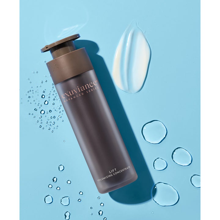 Exuviance Lift Volumizing Concentrate 50 g ansigtsserum i brun pumpeflaske med hvid creme og vanddråber