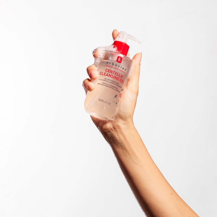 Erborian Centella Cleansing Gel 180 ml mild ansigtsrens i pumpeflaske dækket af blødt renseskum i en hånd.