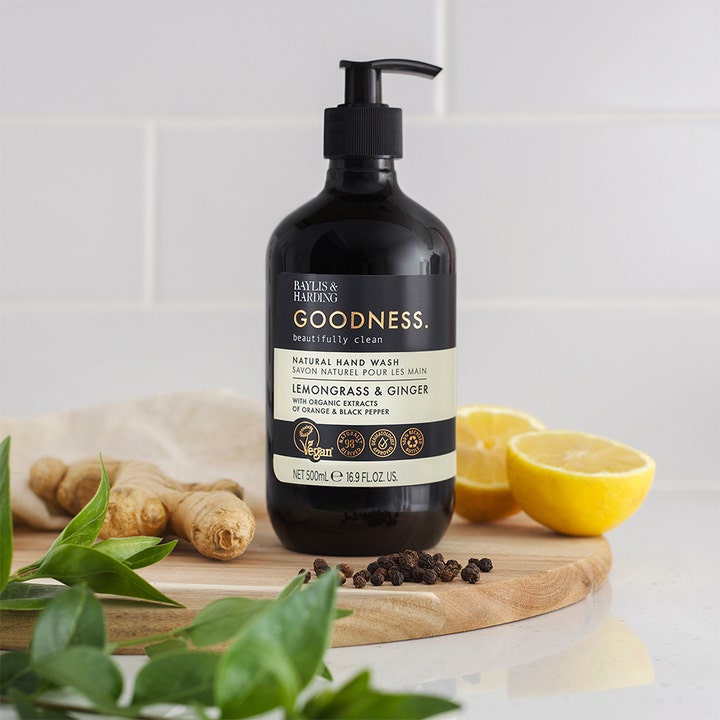 Baylis & Harding Goodness Hand Wash 500 ml i mørk flaske med pumpe ved siden af frisk ingefær og citron.
