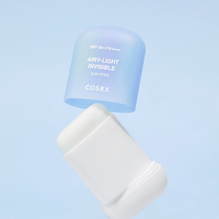 COSRX Airy-Light Invisible Sun Stick 19 g solcreme i stift med lyseblåt gennemsigtigt låg på blå baggrund
