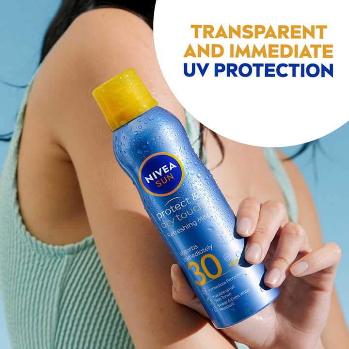 NIVEA Sun Protect & Dry Touch 200 ml solcreme spray giver UV-beskyttelse i en blå flaske holdt mod huden