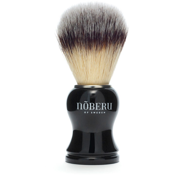 Nõberu of Sweden Synthetic Shaving Brush barberkost der skaber rigt skum med sort blankt håndtag og lyse hår.
