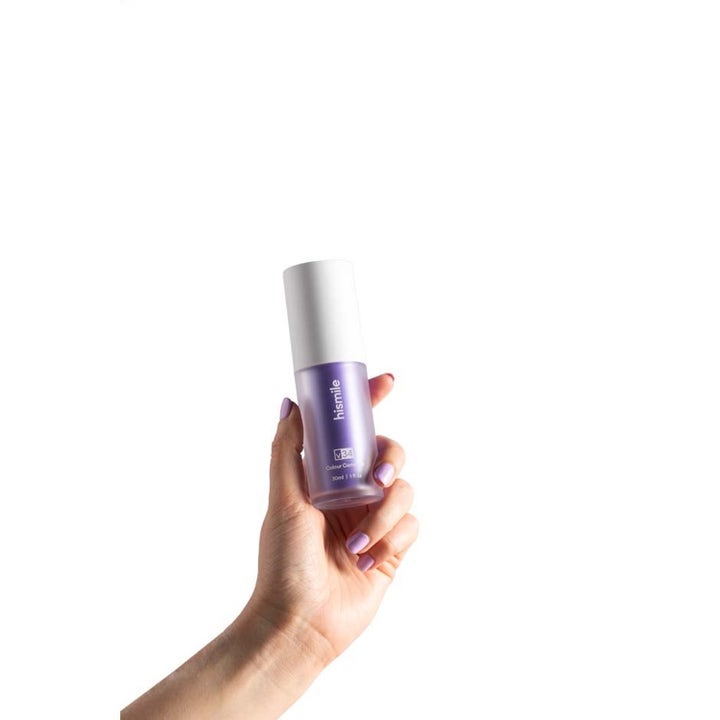 Hismile Whitening Set Colour Corrector 30 ml til farvekorrektion i lilla flaske holdt af en hånd med lilla negle