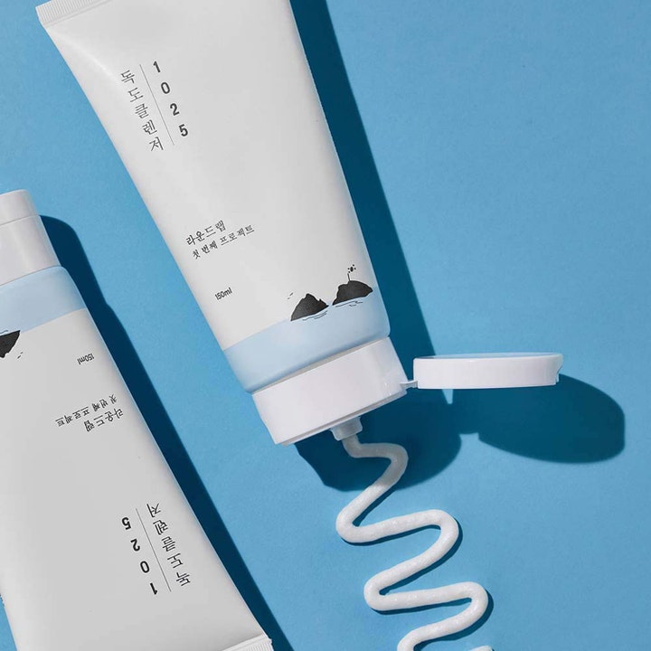 Round Lab 1025 Dokdo Cleanser 150 ml skånsom ansigtsrens i hvid tube med cremet hvid tekstur på blå baggrund.
