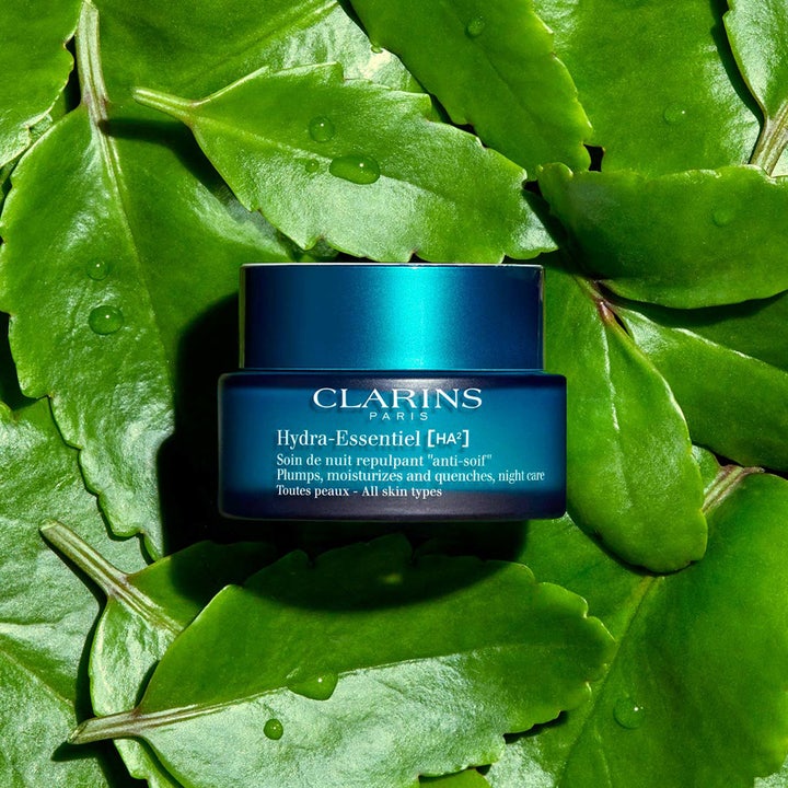 Clarins Hydra-Essentiel 50 ml fugtgivende natcreme i blå krukke placeret på grønne blade med vanddråber