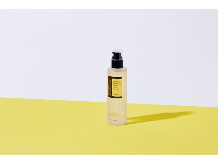COSRX Advanced Snail 96 Mucin Power Essence 100 ml snegleslim essence i klar flaske med sort pumpe på gul overflade