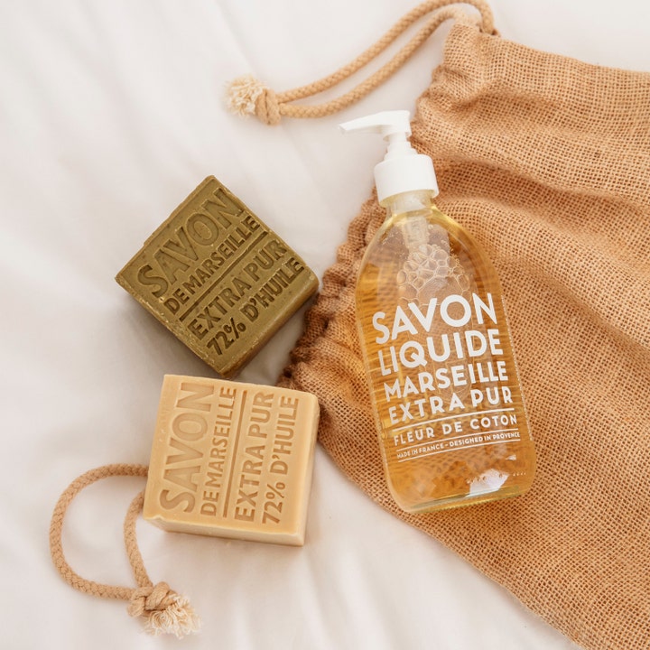 Compagnie de Provence Liquid Marseille Soap Cotton Flower 495 ml håndsæbe med to faste sæbebarer på en jutepose