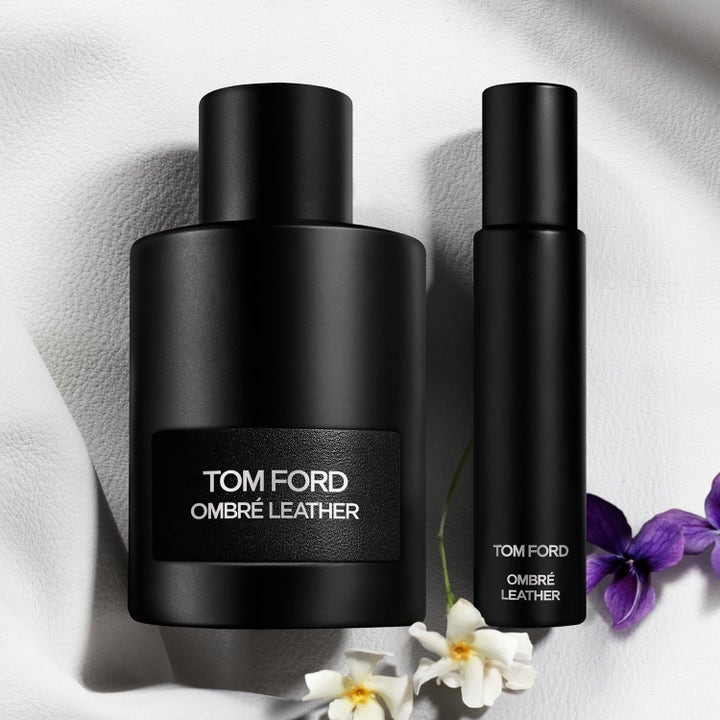 Tom Ford Ombré Leather Eau de Parfum i mat sort flakon med rejsespray på hvid læderbaggrund med blomster