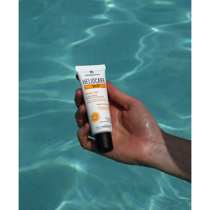 Heliocare 360 Watergel SPF 50+ 50 ml fugtgivende solcreme til ansigtet holdes over en solbelyst swimmingpool