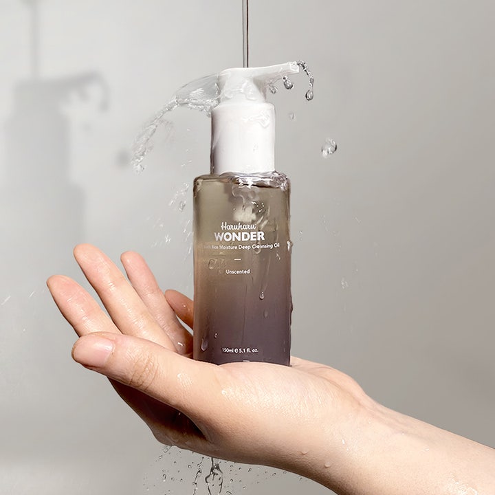 haruharu wonder Black Rice Moisture Deep Cleansing Oil 150 ml dybderensende olie holdt i en hånd med vandstænk