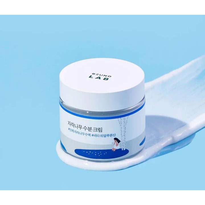 Round Lab Birch Juice Moisturizing Cream 80 ml fugtgivende ansigtscreme i hvid krukke placeret på cremet tekstur