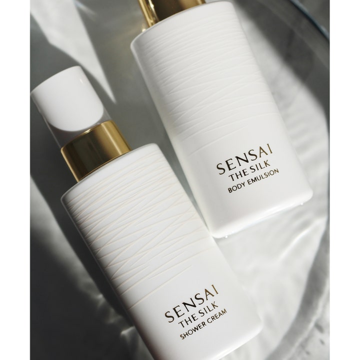 Sensai The Silk Body Emulsion 200 ml fugtgivende bodylotion i hvide flasker med gulddetaljer på en lys overflade