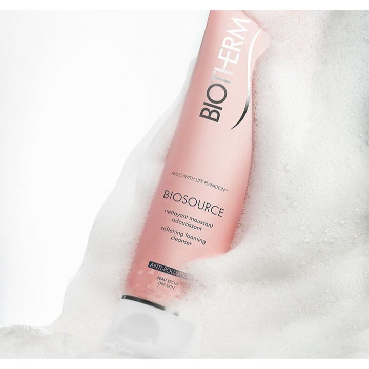 Biotherm Biosource Softening Foaming Cleanser ansigtsrens til tør hud i lyserød tube dækket af hvidt skum.