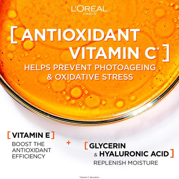 L'Oréal Paris Revitalift Clinical 12% Vitamin C Serum og SPF50 Fluid hudpleje på spejlende overflade med blå himmel