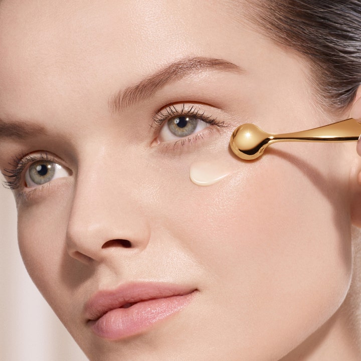 Lancôme Absolue The Eye Cream 20 ml revitaliserende øjencreme påført med en kølende guldfarvet applikator