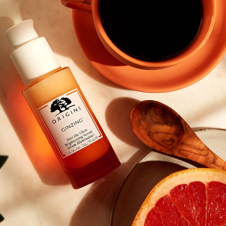 Origins GinZing Into the Glow Brightening Serum 30 ml glødgivende serum i orange flaske med kaffekop og grape